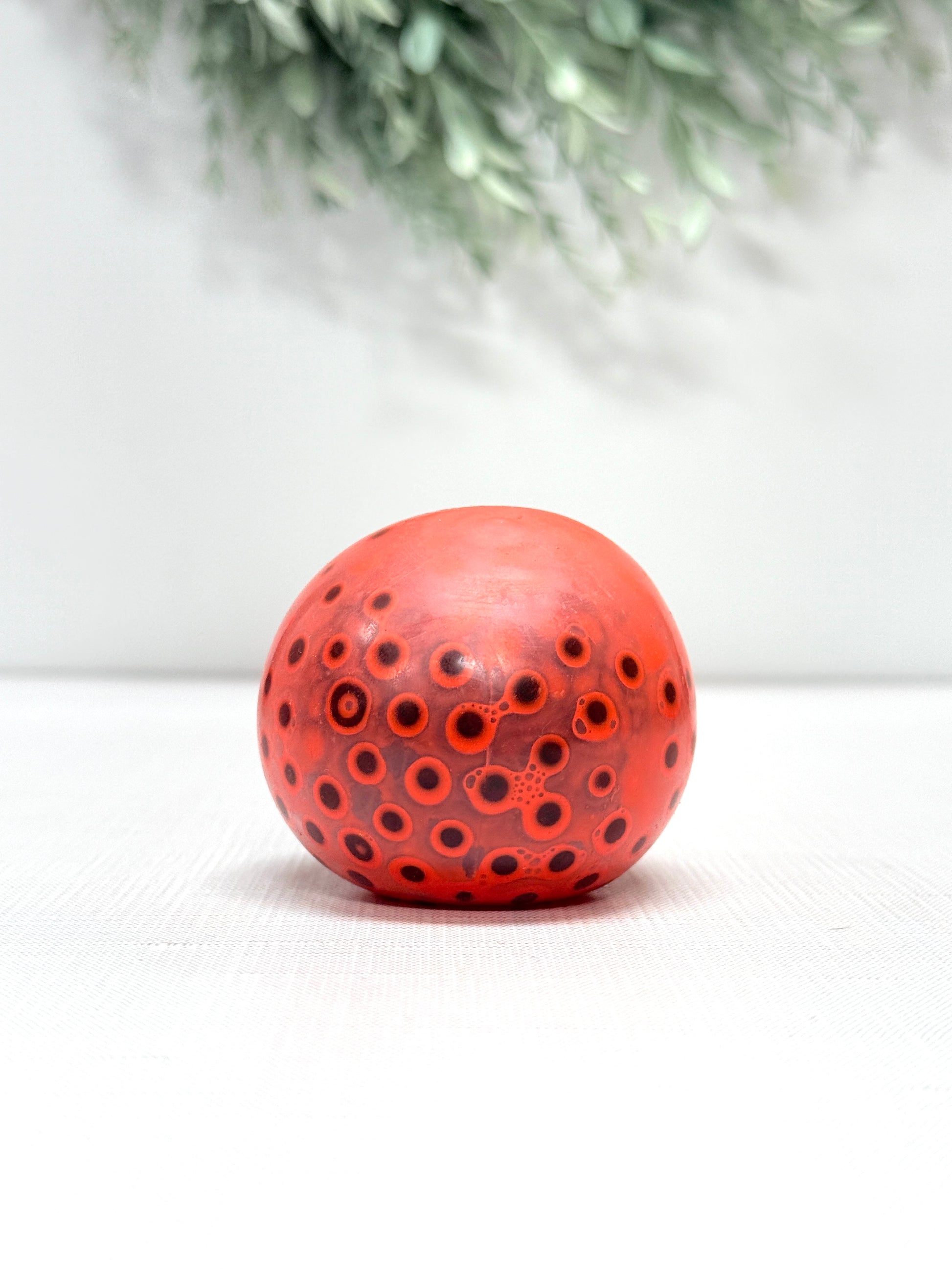 OOZE Ball sensory squeeze toy available in pink, orange, green, and yellow