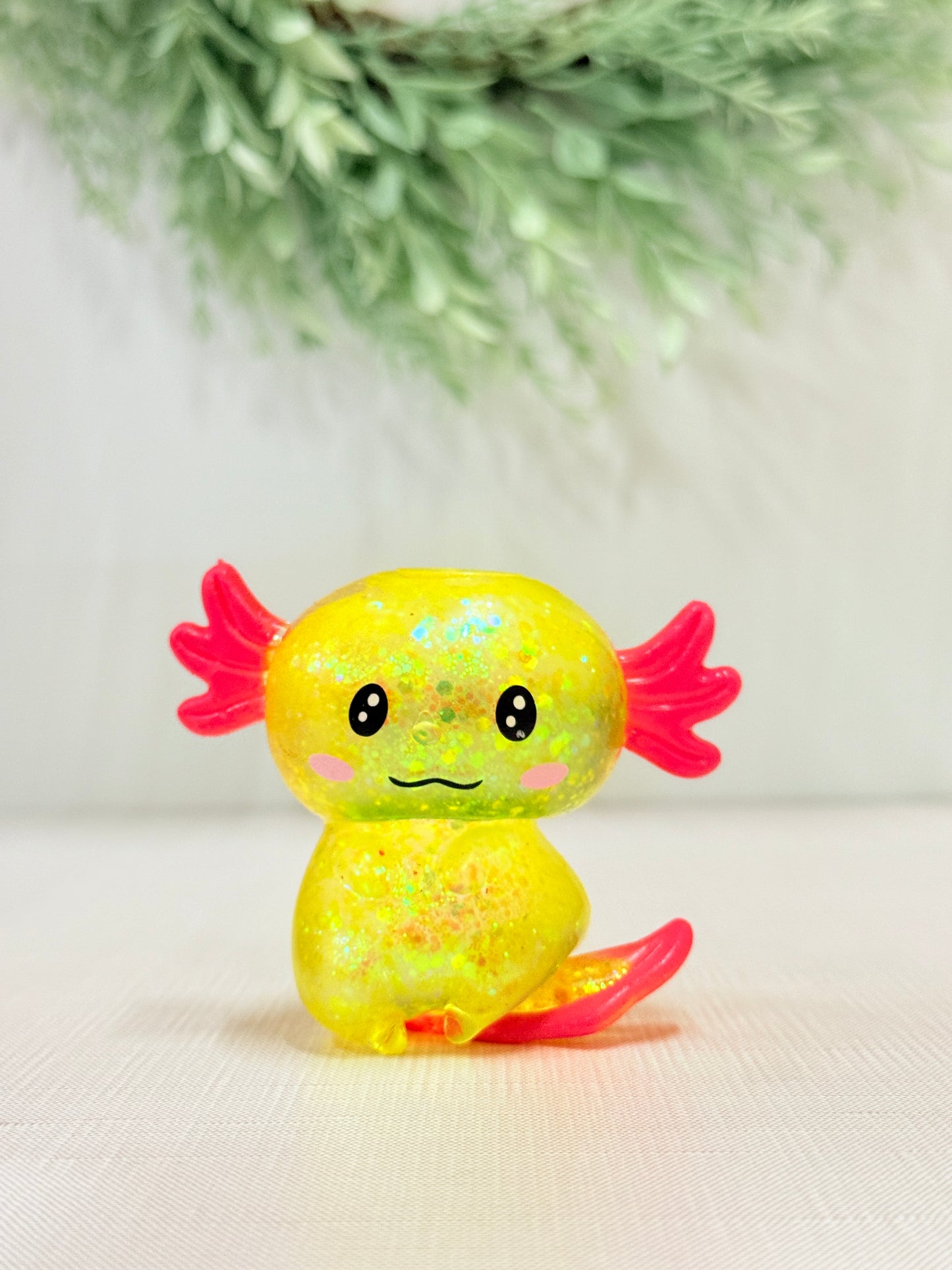 Glittery axolotl squish toy in yellow sensory fidget