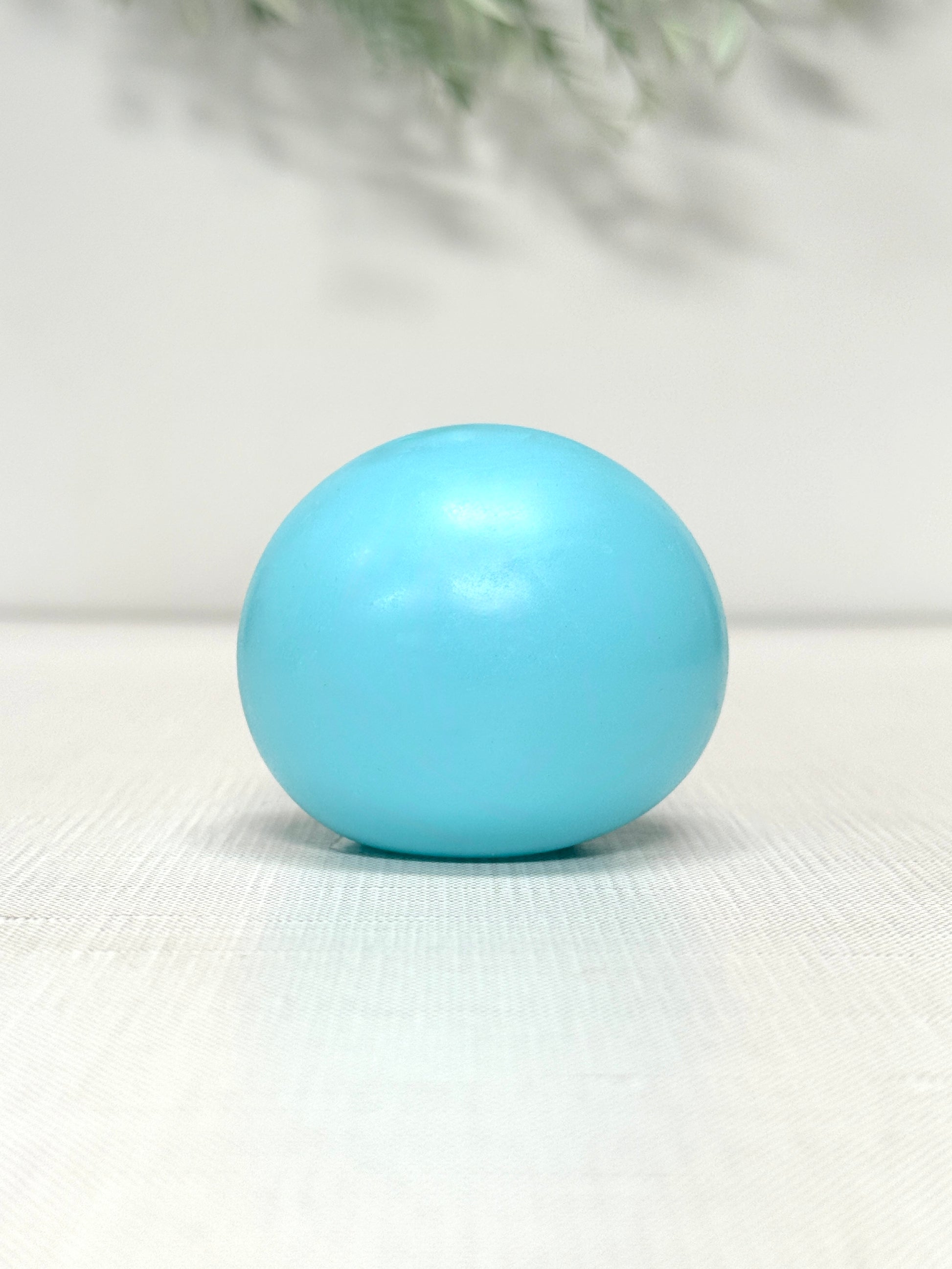 Glow in the dark gummy squish ball sensory toy available in green, blue, and yellow