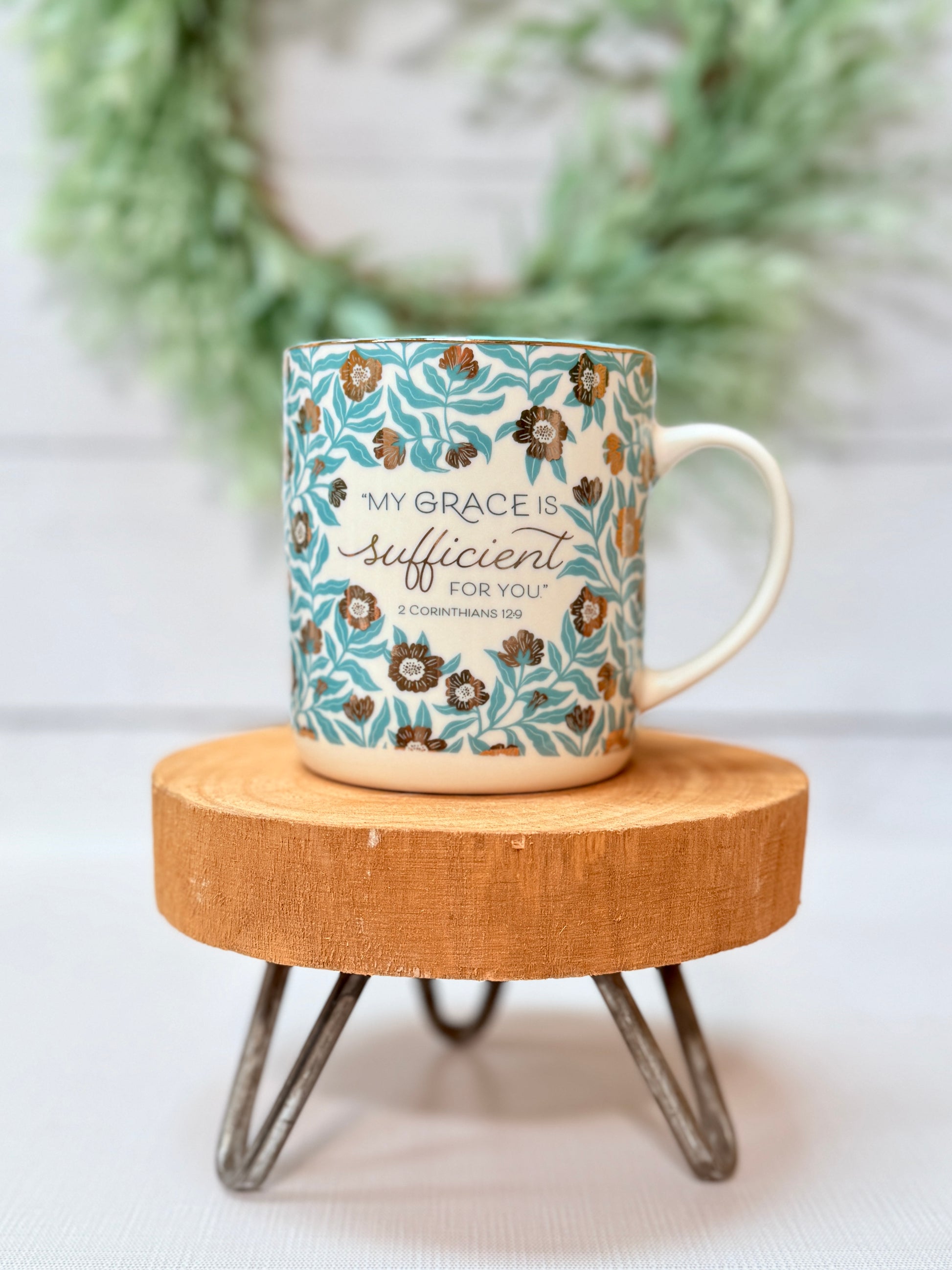 My Grace Is Sufficient scripture coffee mug with faith-based design styled on a wooden stool with greenery background